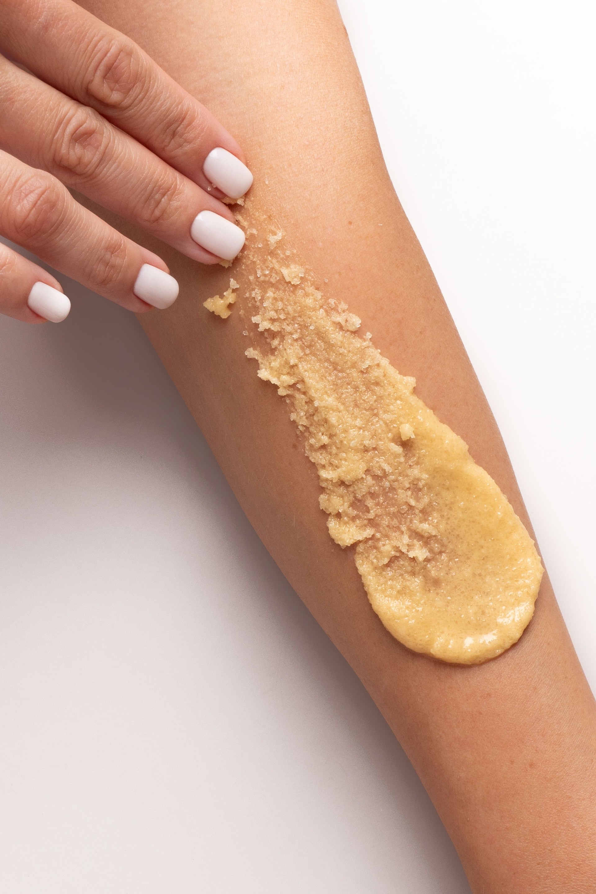 Yellow scrub swatch smudge smear on woman's hand, textured scrub