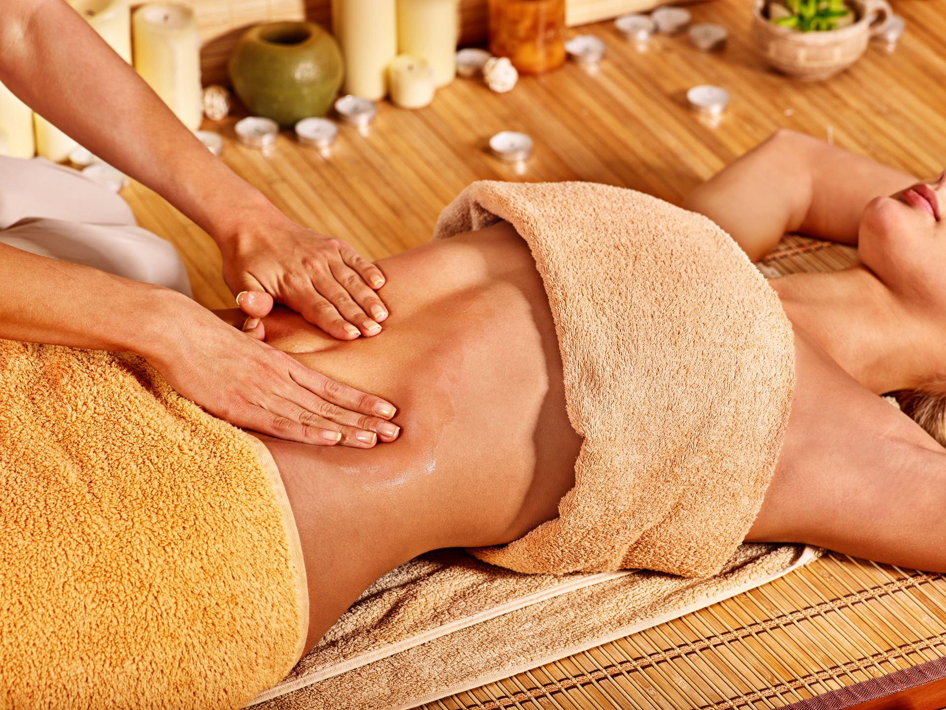 Woman getting massage in bamboo spa